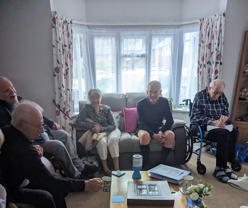 5 people sitting around a coffee table in a living room
