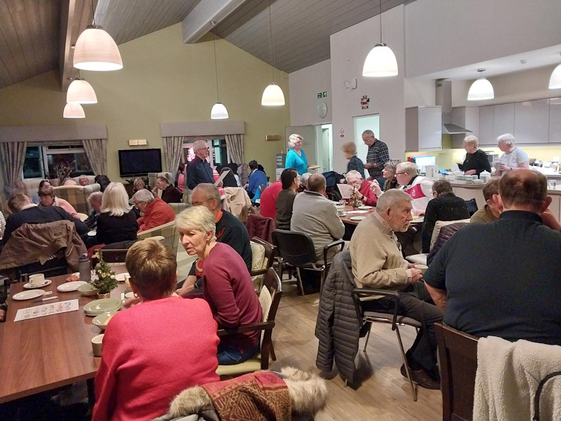 Lots of people seated at tables doing a quiz
