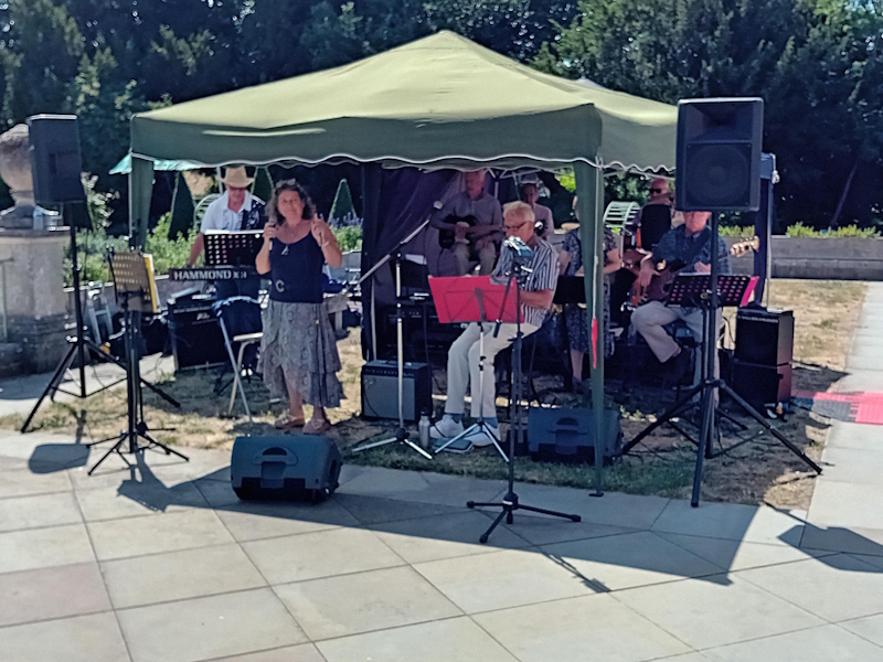 Musicians performing under a gazebo, with female lead singer